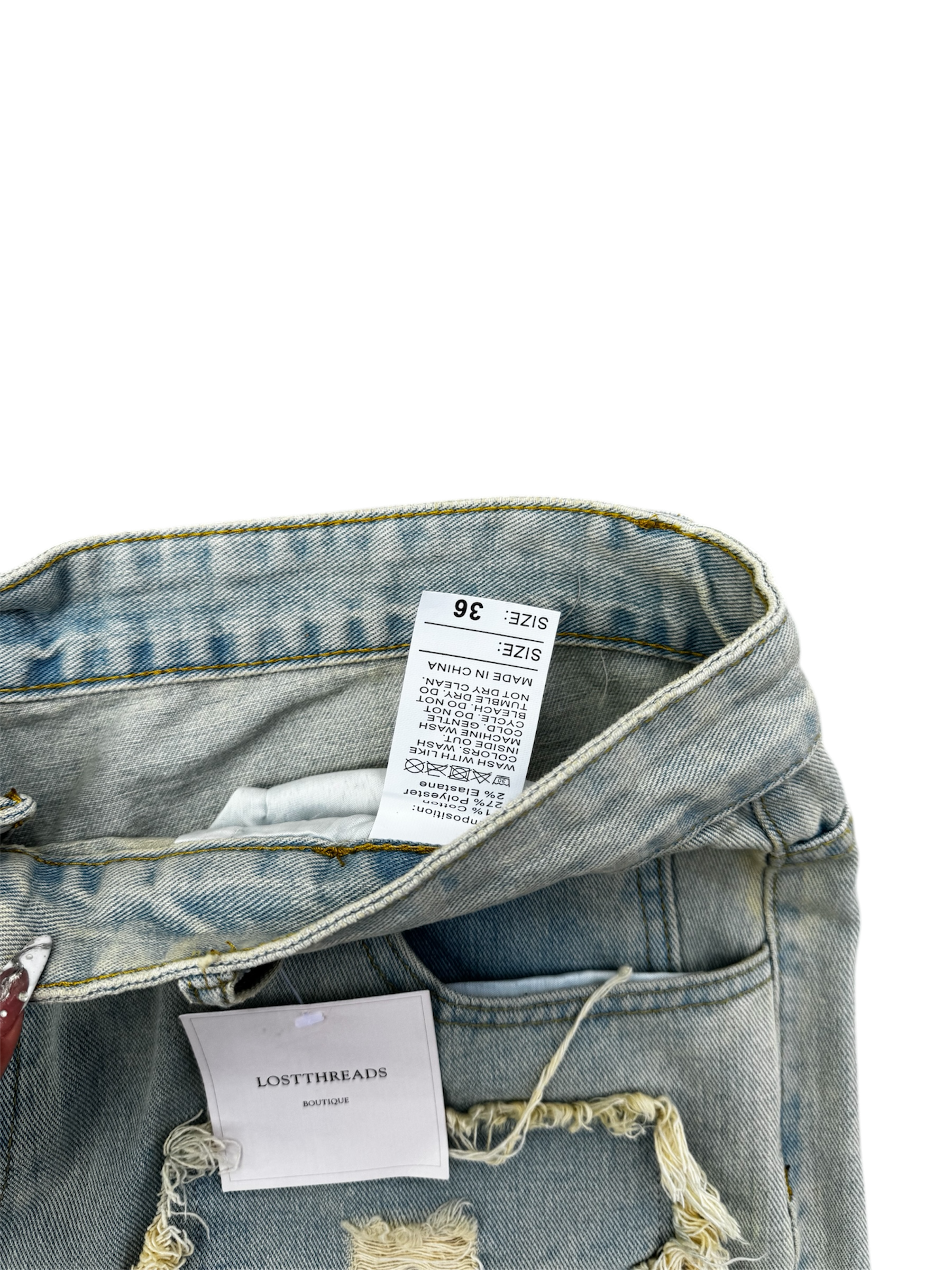 Cream / light wash distressed denim jeans